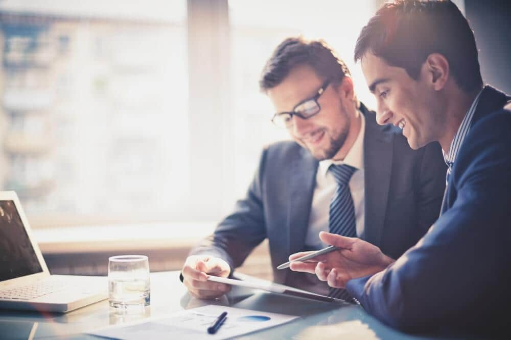 Two man discussing having a look at the tab and smiling