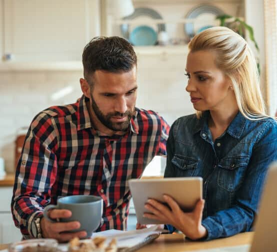 A woman with a tab and a man with a cup of coffee having discussion